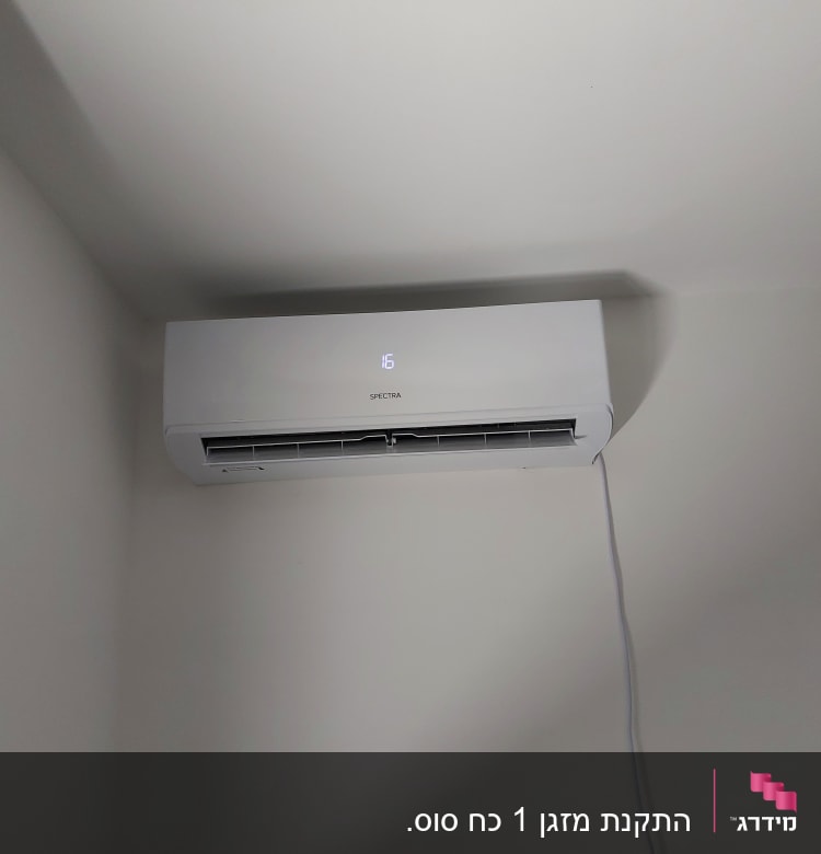 מזגן קיר לבן מותקן על קיר עם תצוגה דיגיטלית